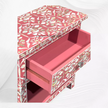 Elegant pink bedside table with storage and pearl inlay detail