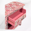 Elegant pink bedside table with storage and pearl inlay detail