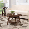Arlo round wooden coffee table with lower shelf on a geometric rug beside a cream sofa