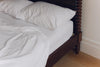 Bodhi Bobbin Four Poster Solid Wood Bed corner view with bedding