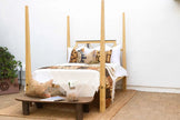 Colonial Bleached Lattice Four Poster Bed styled with a bench and pillows