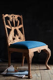 Hare Hand Carved Wooden Dining Chair against a dark background