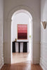 Kala Sculptural Plank Leg Wooden Console Table in an arched hallway