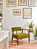 Paxton Solid Wood Upholstered Armchair in a room with framed art
