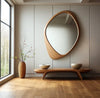 Pebble Irregular Wooden Frame Wall Mirror over a low wooden bench