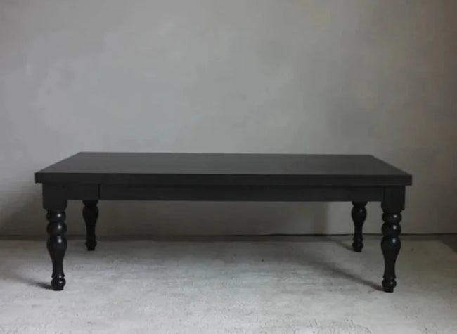 Rhea rectangular coffee table in matte black with hand-carved spindle-turned legs