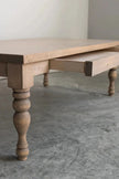 Close-up of a turned baluster leg and open drawer on the natural Rhea coffee table
